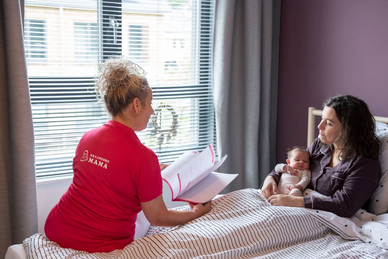 Kraamverzorgende neemt de rapportage door met de moeder aan het bed